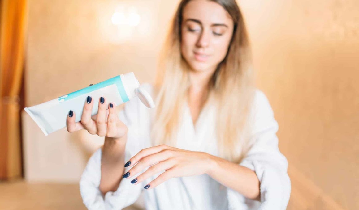 Woman applying cosmetic cream for hands, skincare