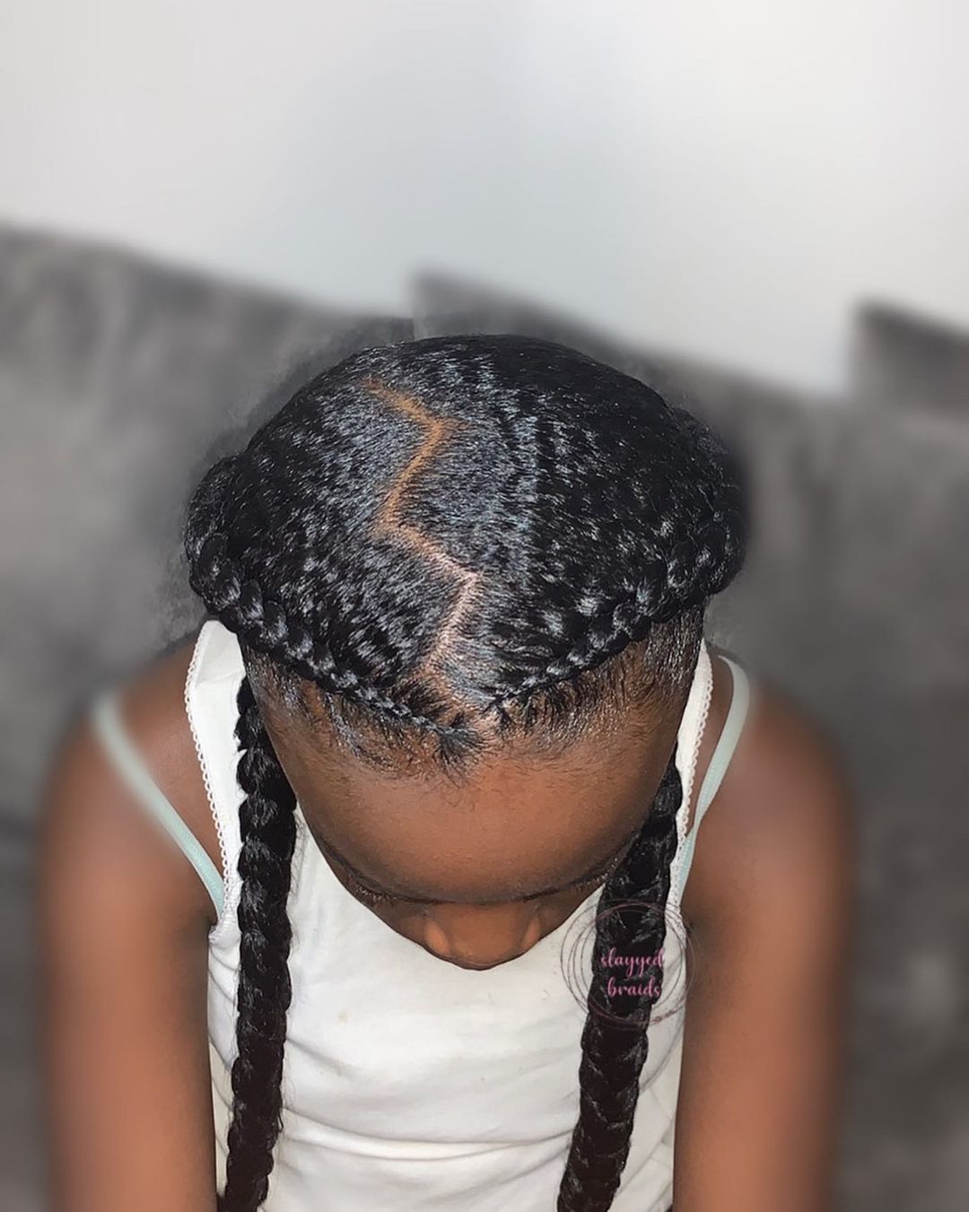 Two sleek braids with a zig zag part