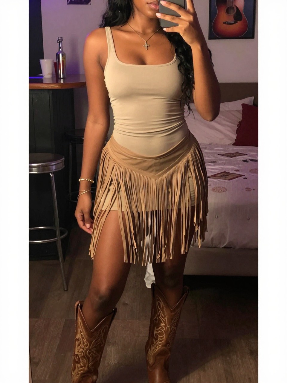 selfie of a black woman in a fringe skirt and fitted top with cowboy boots, standing in a bar or club with country music vibes, cropped at NECK so face doesn't show, in a feminine-themed bedroom, warm moody lighting, iPhone photo quality.
