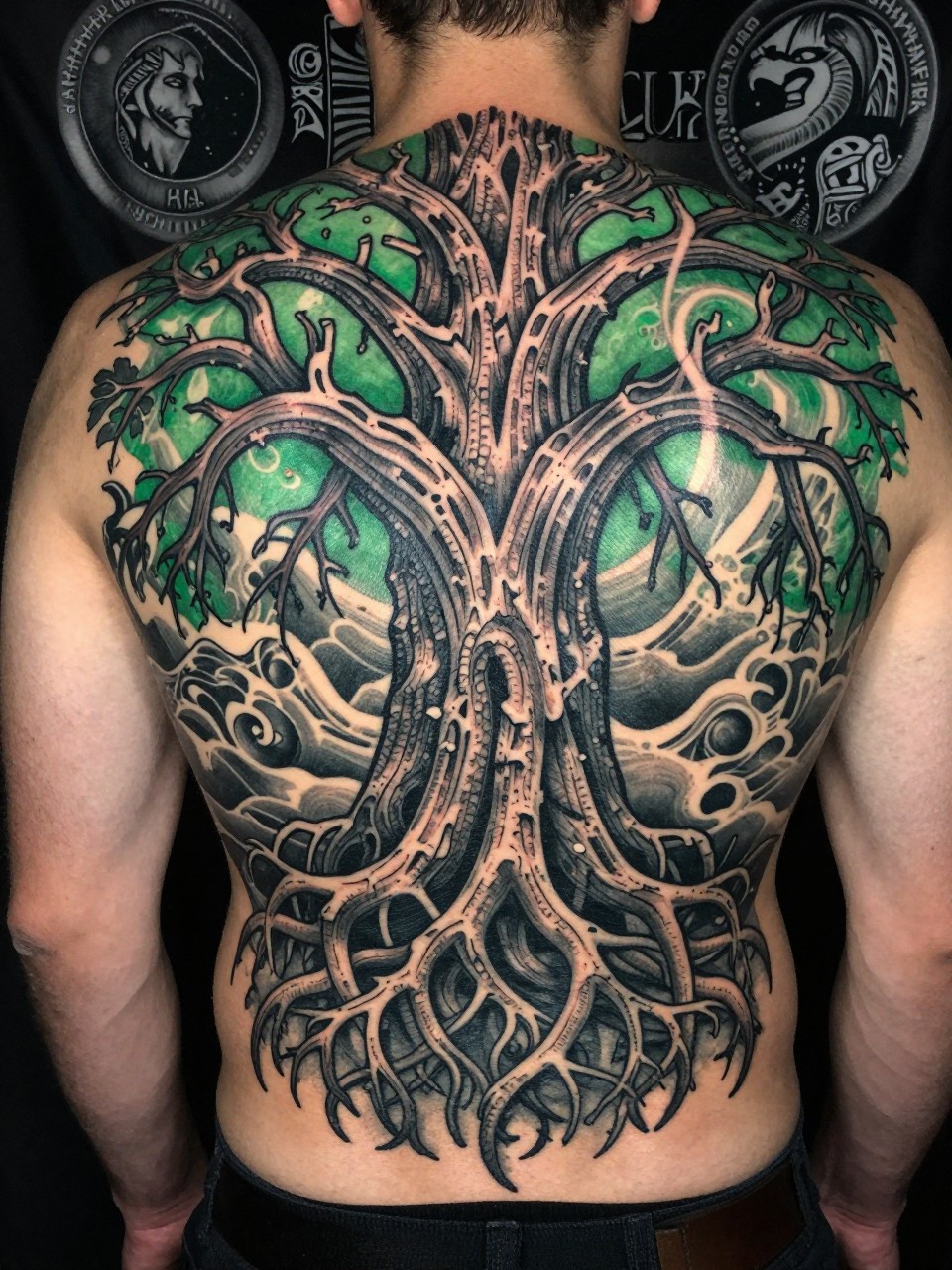 half back tapestry: Yggdrasil tattoo on the back of american man with intricate bark texture, its roots tangled and deep, its branches weaving across the shoulders. Nine worlds hinted in the background. Rich blackwork with green accents."