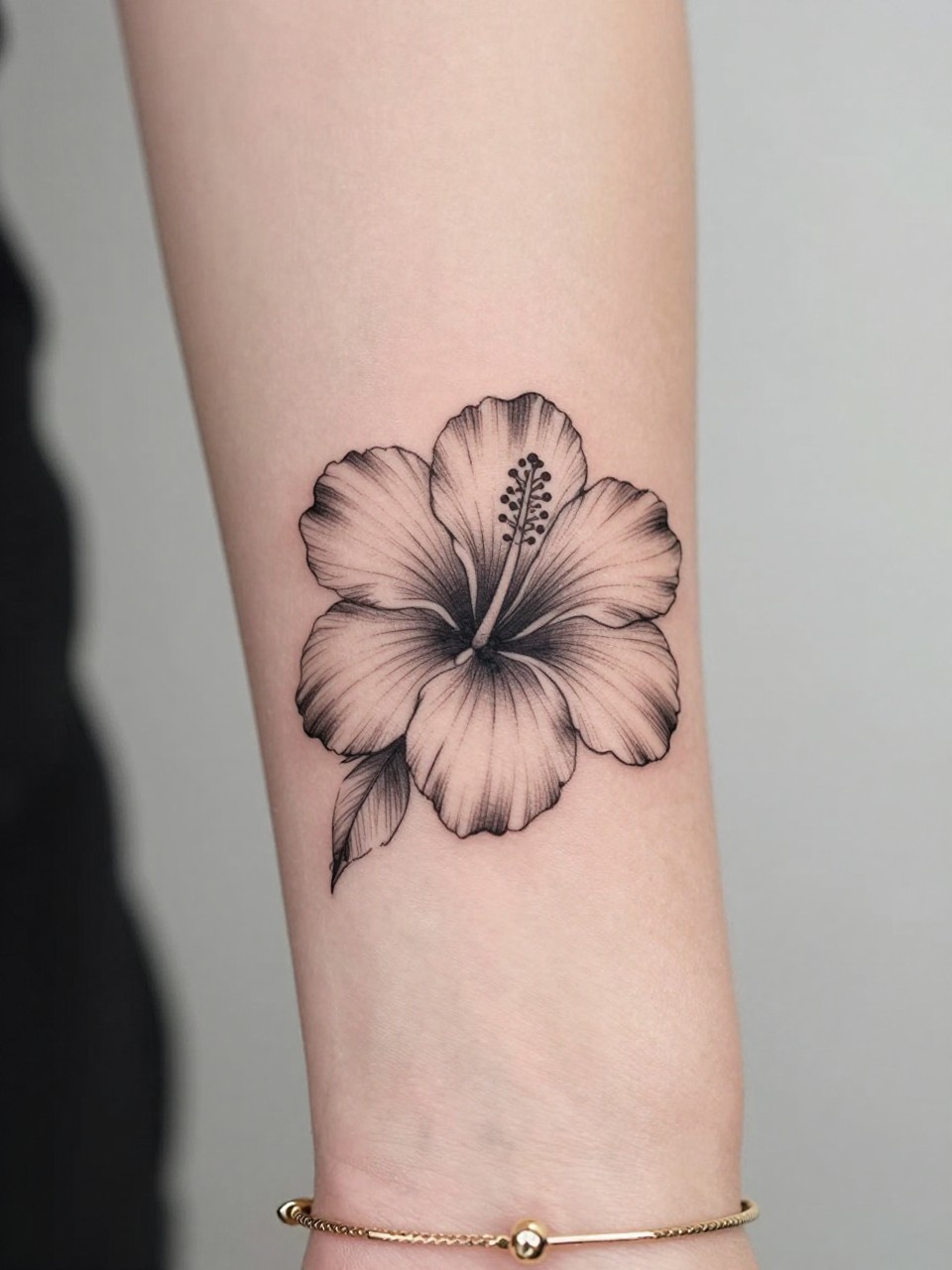Image Prompt: "Macro shot of a fine line hibiscus flower tattoo on the inner wrist, black ink floral design with delicate open petals, light shading, minimalist but striking style, realistic skin texture, delicate gold bracelet, tight crop, feminine tattoo inspiration image, clean soft background, tattoo-centered composition (no watermarks on images)"