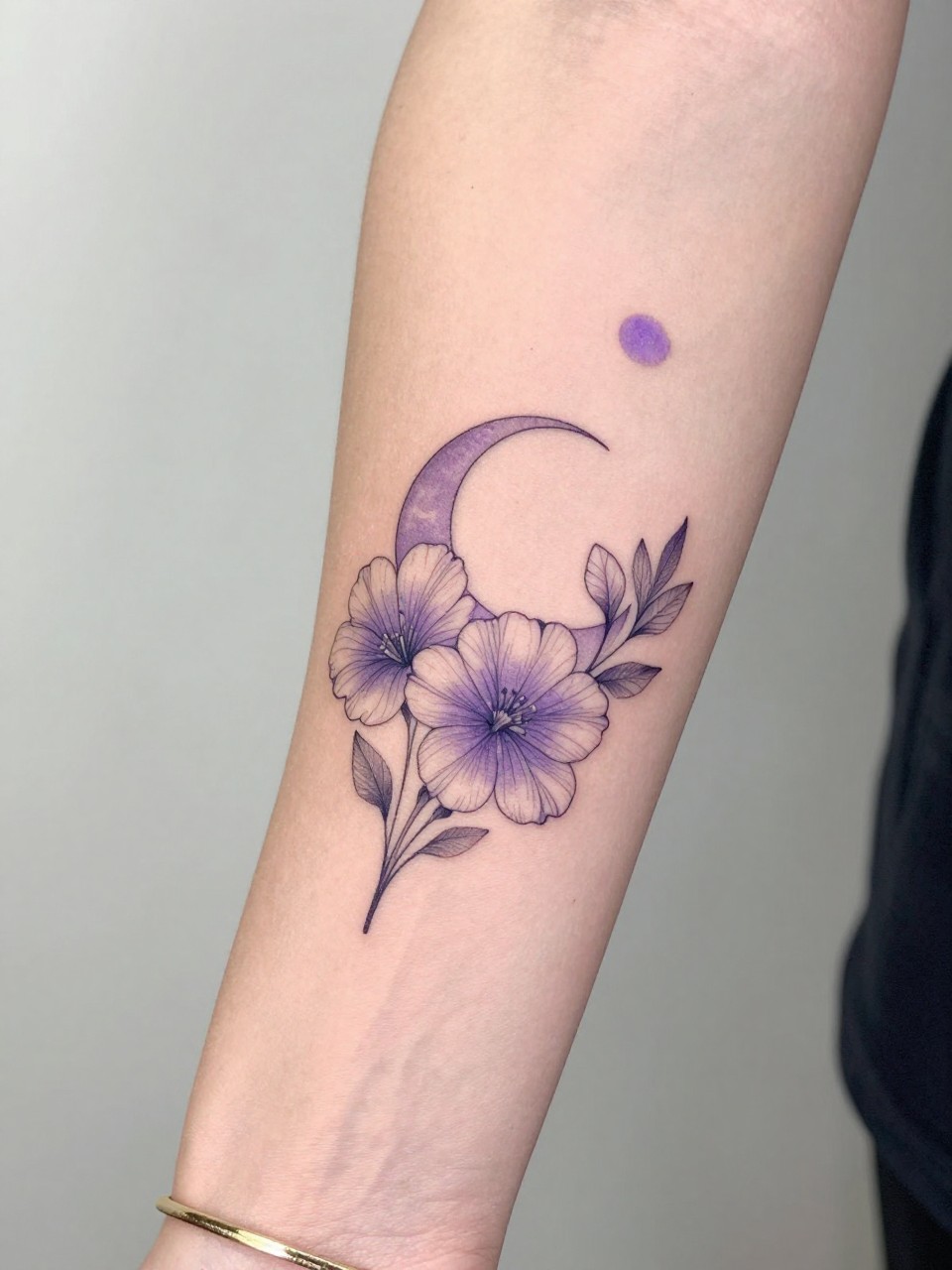 Image Prompt: "Design-focused close-up of a violet tattoo with a tiny crescent moon on the inner arm, black ink fine line floral design, rounded petals, soft shading, delicate celestial accent, realistic skin texture, gold bracelet lightly visible, feminine modern tattoo inspiration photo, clean soft background, tattoo is the hero (no watermarks on images)"