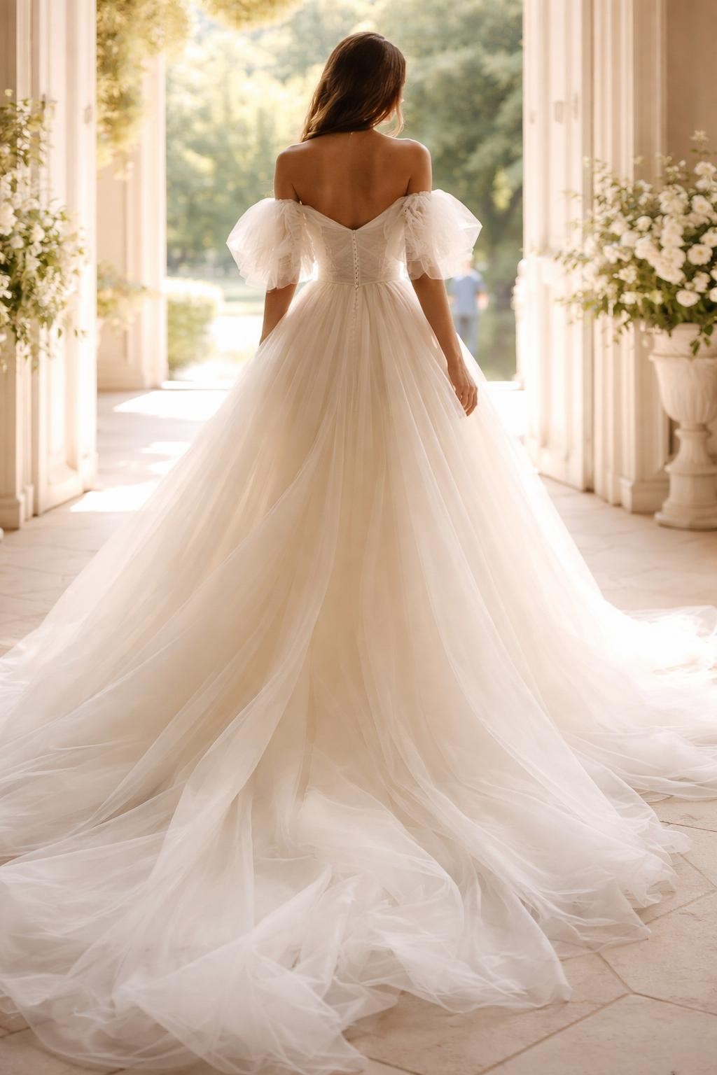 Image Prompt: A high-fashion bridal editorial photo of an ethereal off-shoulder organza wedding dress in a bright chapel entrance or elegant garden venue. Show the bride from the shoulders down or from a back three-quarter view with the face fully hidden. The gown has an off-shoulder neckline, airy organza layers, a fitted bodice, and a soft full skirt with gentle volume. Use natural light, realistic organza texture, refined bridal styling, luxury wedding magazine quality, no visible face, no text, no watermark. (no watermarks on images)