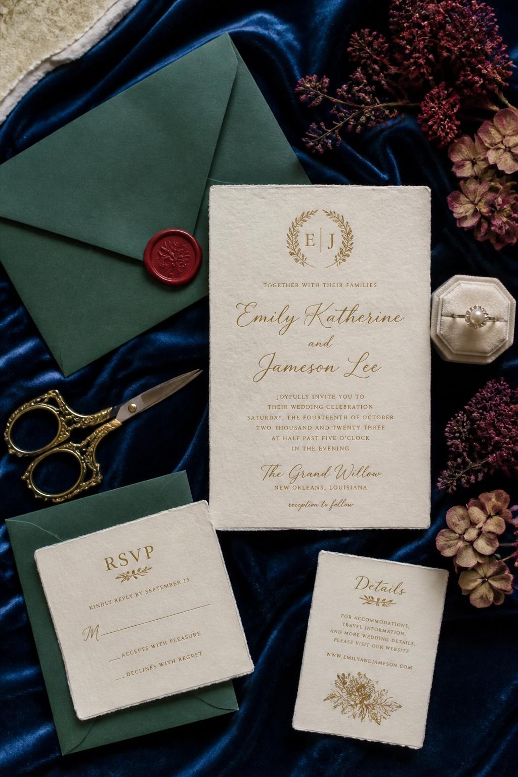 Realistic DSLR flat lay of a fall wedding invitation suite on sapphire blue velvet fabric, cream handmade paper invitation, emerald envelope, ruby wax seal, gold calligraphy, dried burgundy flowers, antique brass scissors, pearl ring box, soft side window light.