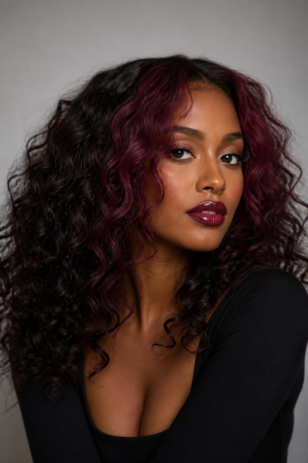 Image Prompt: A stylish woman with dark curly hair and berry plum money piece highlights framing the face, black-brown base with bold berry-purple front sections, defined curls with shine, warm deep skin tone, glossy berry lips, subtle bronzed makeup, fitted black top, clean neutral studio background, close-up beauty portrait, realistic DSLR photo, focus on face-framing berry plum color, no text, (no watermarks on images)