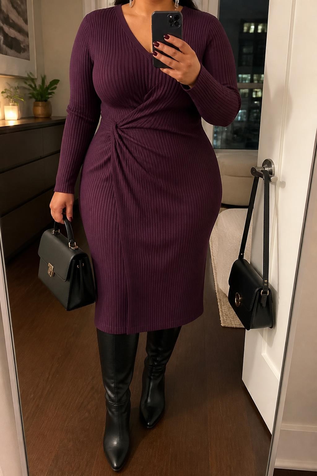 Mirror selfie of a plus size woman wearing a plum purple ribbed knit midi dress with long sleeves, a V-neckline, and gentle gathering at one side of the waist, black leather knee-high riding boots, a black structured handbag, and silver drop earrings, clearly showing the exact clothing items, plum ribbed knit, waist gathering, black footwear, and accessories listed, holding a phone in front of a mirror, cropped at the neck so her face is hidden, relaxed graceful selfie stance, in a stylish city apartment with warm moody lighting, a small plant on a dresser and a handbag hanging on a door handle, realistic Thanksgiving church outfit, latest iPhone photo quality.