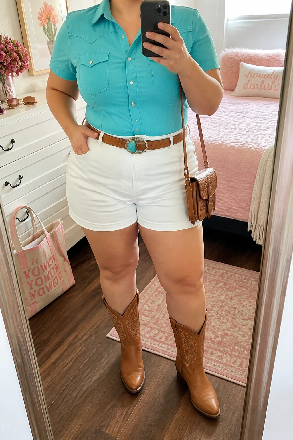 Mirror selfie of a plus size woman wearing crisp white high-waisted denim shorts with a relaxed mid-thigh length, a fitted turquoise Western shirt with short sleeves and silver snap buttons, tan leather mid-calf cowboy boots, a tan Western belt with a turquoise buckle, and a small tan crossbody bag, clearly showing the exact clothing items, white denim, turquoise shirt, silver snaps, tan boots, belt, and accessories listed, holding a phone in front of a mirror, cropped at the neck so the face does not appear, relaxed bright selfie pose, in a feminine-themed bedroom with natural window light, sunglasses placed on a dresser and a tote bag resting on the floor, realistic summer outfit, latest iPhone photo quality.